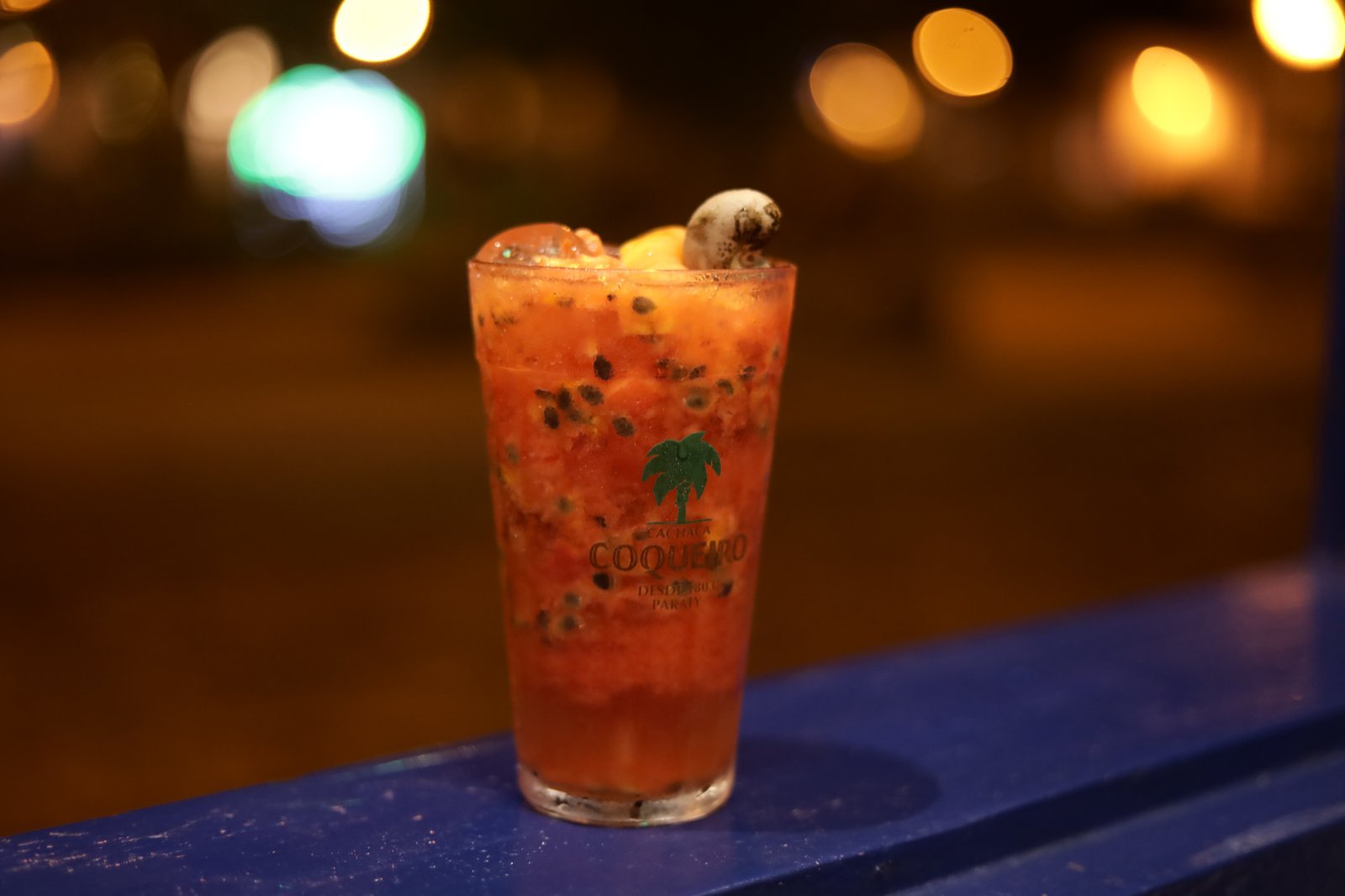Drink artesanal com cachaça e frutas frescas na noite de Paraty