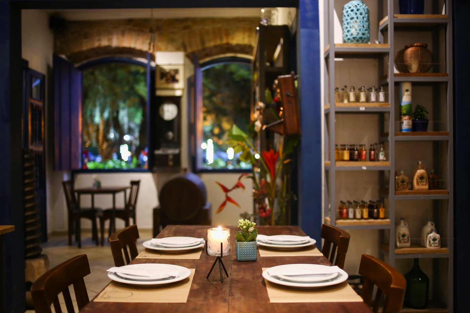 Mesa à luz de velas e barricas de envelhecimento de cachaça artesanal